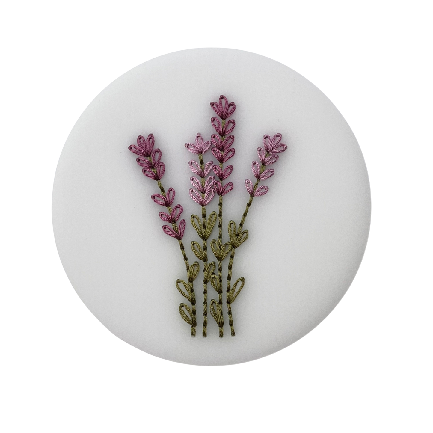 A completed embroidery kit depicting a bouquet of flowers arranged on a round acrylic disk.