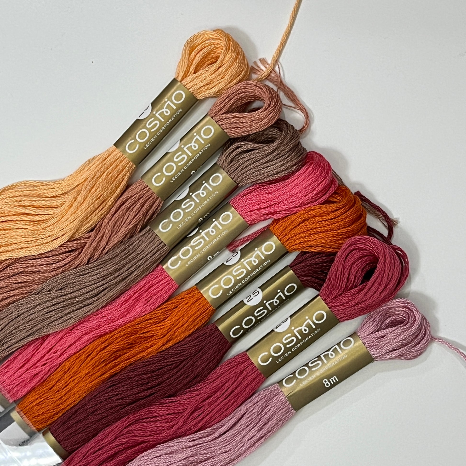 A warn color palette of Cosmo embroidery floss in orange and reds